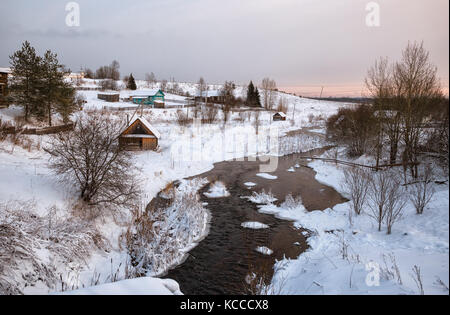 Russische Dorf im Winter auf der Bank der schnell aufgetaut Fluss Stockfoto