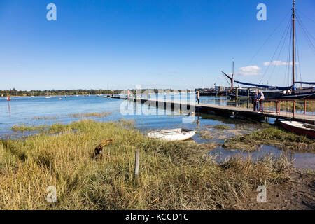 Und ältere Paare und eine Frau stehen auf der Segelclub Steg am Stift Mühle und den Fluss Orwell, Chelmondiston, Essex, UK suchen Stockfoto