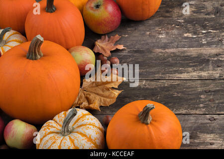 Herbst ernte noch leben mit Kürbisse, Äpfel, Haselnuss und Ahornblätter auf hölzernen Hintergrund Stockfoto