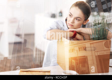 Nachdenklich düstere Frau sitzt im Büro mit ihr Eigentum Stockfoto