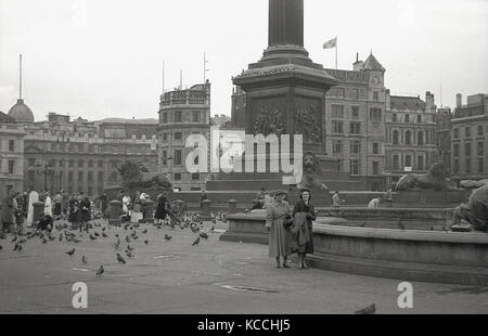 1944, historisches Bild von einigen Besuchern des berühmten Trafalgar Square in Central London, England, Großbritannien. Menschen, die die Tauben an der Basis von Nelson's Column füttern. Stockfoto