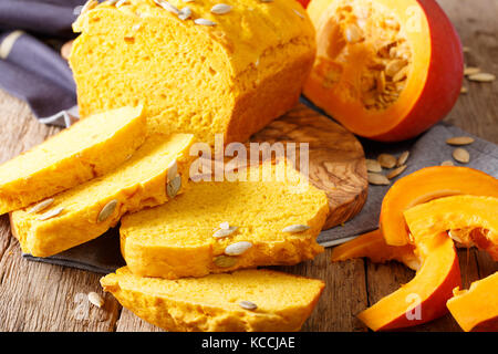 Frisch gebackener Kürbis Brot auf Holzbrett mit Saatgut und Kürbisse. Horizontale Stockfoto
