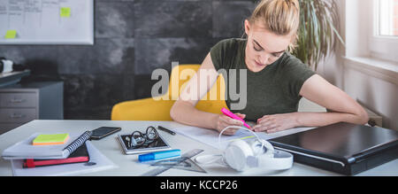 Junge Geschäftsfrau Schreibarbeit zu tun im Büro Stockfoto