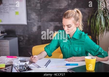 Junge Geschäftsfrau Schreibarbeit zu tun im Büro Stockfoto