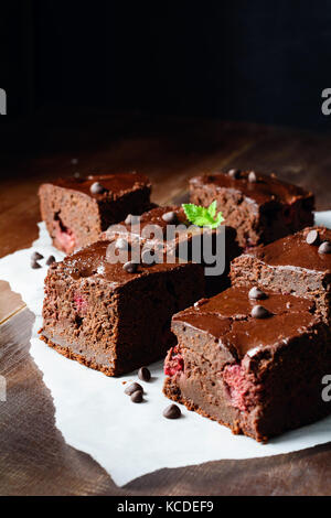 Chocolate Brownie Quadrate mit Kirschen auf Pergamentpapier. Detailansicht, Vertikal, Kopie Raum Stockfoto