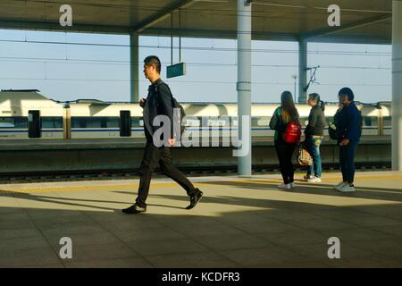 Bahnsteig, Zug und Passagiere auf dem neuen chinesischen Bahnhof Baoding auf der Pekinger Shijiazhuang Hochgeschwindigkeitsstrecke. Provinz Hebei, China Stockfoto