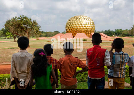 AUROVILLE, INDIEN: Touristen vor dem Matrimandir, der Meditationshalle, die das Symbol der Stadt ist Stockfoto