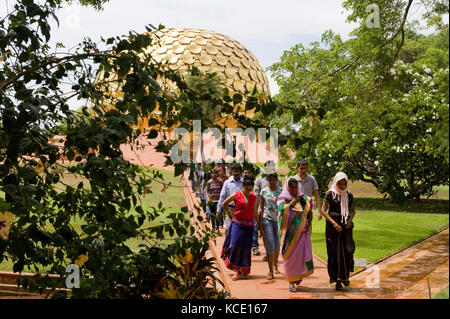 AUROVILLE, INDIEN: Touristen vor dem Matrimandir, der Meditationshalle, die das Symbol der Stadt ist Stockfoto