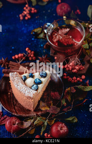 Von einem Stück Pumpkin Pie mit Puderzucker in eine dunkle Herbst Szene mit Rauch zu schließen. Süße halloween Konzept, kopieren. Konzeptionelle stilisiert Stillleben mit Herbst Blätter und Beeren. Stockfoto