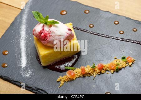 Käsekuchen mit roten Früchten und Eis. Stockfoto