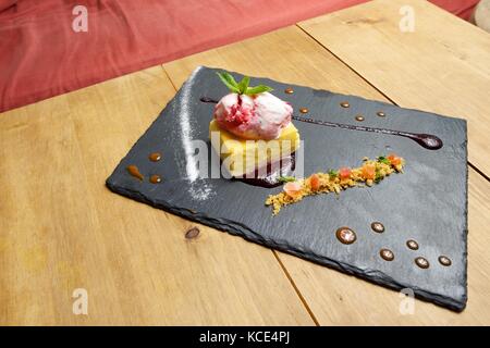 Käsekuchen mit roten Früchten und Eis. Stockfoto