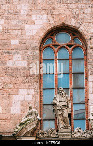 Riga, Lettland. Ansicht schließen der alten Kalkstein Skulptur von Mensch mit einem Buch im barocken Stil an der Fassade der St. Peter Kirche, berühmten architektonischen Ein Stockfoto