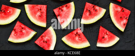 Scheiben der Reife Wassermelone auf einen schwarzen Stein Hintergrund Stockfoto