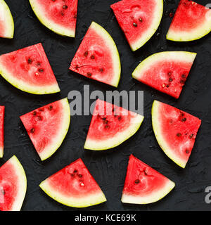 Scheiben der Reife Wassermelone auf einen schwarzen Stein Hintergrund Stockfoto