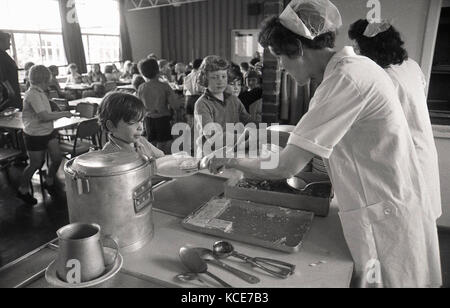 1970 s, historischen, Schule Abendessen Damen Essen für Kinder mittags servieren, Langbourne Grundschule, Dulwich, London, SE21, England, UK. Stockfoto