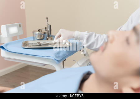 Zahnarzt hand nehmen einige Instrumente aus Metall Fach in der Klinik. Zahnpflege und gesunde Wartungskonzept Stockfoto