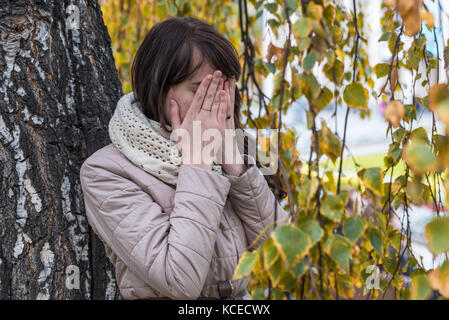 Porträt eines weinenden Mädchen mit lockigem Haar, ihr Gesicht und ihre Hände Stockfoto