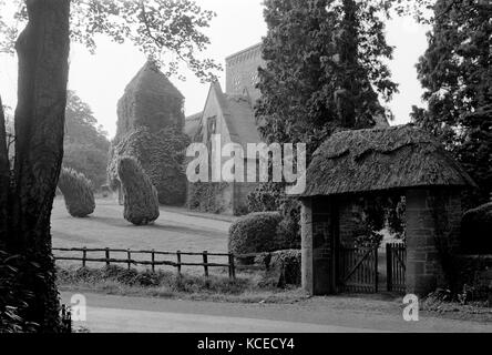 All Saints Church, brockhampton, in der Nähe von Ross-on-Wye, herefordshire. Die lych Gate mit Kirche im Hintergrund. Diese Kunst und Handwerk Kirche gebaut wurde b Stockfoto