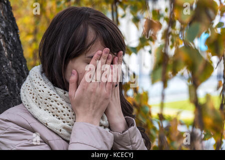 Porträt eines weinenden Mädchen mit lockigem Haar, ihr Gesicht und ihre Hände Stockfoto