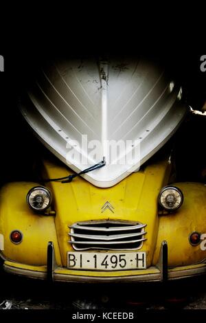 Ein alter Citroen 2CV in einer Garage mit einem umgedrehten Boot darauf. Modell AK3ST 400. Stockfoto