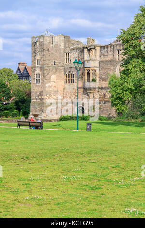 Leute sitzen auf einer Parkbank, mit Blick auf die Burg von Newark, Newark-on-Trent, Nottinghamshire UK Stockfoto