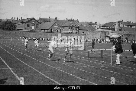 1965, historisches Bild der männlichen Schüler an der Thomas Hardye Boys School in Blackpool, England, UK, konkurrieren in einem Wettlauf auf einer Grasbahn während der jährlichen Tag des Sports. Stockfoto