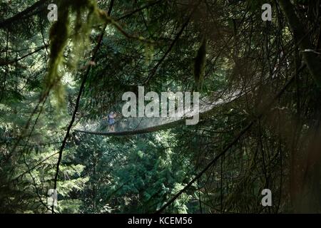 Ein paar überqueren Sie die Hängebrücke in Lynn Canyon Park in der Nähe von Vancouver in British Columbia, Kanada. Stockfoto