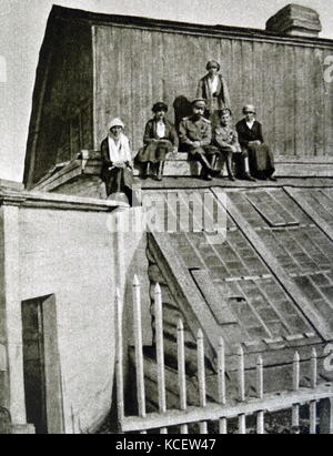 Die ehemalige Zar Nikolaus II. und seine Kinder, (L - r) Olga, Anastasia, Nikolaus II., Tatiana (stehend), Alexej und Maria. Fotografiert sitzen auf dem Dach eines Gewächshauses, während ihrer Gefangenschaft in Tobolsk 1917 Stockfoto