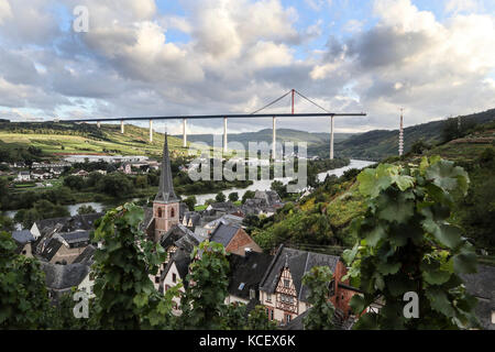 Die Stadt Urzig, in der Mosel, Deutschland, mit dem unvollendeten Autobahn Brücke über das Tal in der Ferne Stockfoto