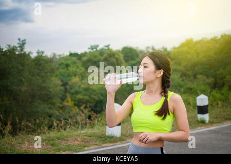 Sport und Gesundheit Lebensstil, schöne junge Frau trinkt Wasser nach dem Training. Stockfoto