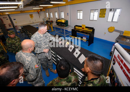 U.S. Army State Command Sgt. Maj. Robert Brickley zeigt auf ein Stück repariertes Blech, als die kolumbianische Armee ihre Blechreparaturfähigkeiten in Tolemaida, Kolumbien, 21. Februar 2013 demonstriert. Mitglieder der South Carolina National Guard besuchten Kolumbien im Rahmen des Staatspartnerschaftsprogramms zwischen der South Carolina National Guard und dem Land Kolumbien. (USA Armee Foto von Staff Sgt. Jorge Intriago/Freigegeben) Stockfoto