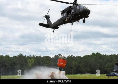 Ein U.S. Army UH-60 Black Hawk Hubschrauber Tropfen Wasser aus einem Hubschrauber Schaufel während einer Ausstellung an der South Carolina National Guard in der Luft und am Boden Expo bei mcentire joint National Guard Base, South Carolina, 5. März 2017. Diese Expo ist eine kombinierte Waffen Demonstration der Fähigkeiten von South Carolina National Guard Flieger und Soldaten und sagen Danke für die Unterstützung von Kollegen Südcarolinians und der umgebenden Gemeinschaft. (U.s. Army National Guard Foto: Staff Sgt. Kevin Pickering) Stockfoto