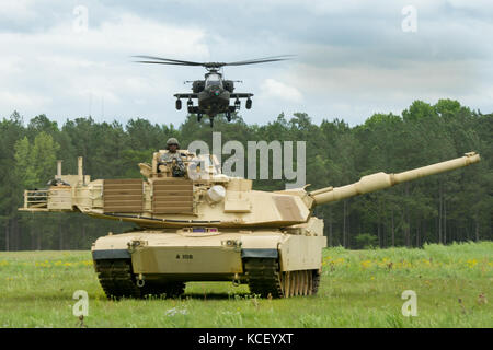 Ein US Army M1 Abrams Kampfpanzer und eine AH-64 Kampfhubschrauber bietet Feuer macht, während in einer kombinierten Waffen Demonstration an McEntire Joint National Guard Base, South Carolina, 5. Mai 2017 teilnehmen. Diese Expo ist die Fähigkeiten von South Carolina National Guard Flieger und Soldaten zur Schau zu stellen und sagen Danke für die Unterstützung von Kollegen Südcarolinians und der umgebenden Gemeinschaft. (U.S. Army National Guard Foto von Sgt. Brian Calhoun) Stockfoto