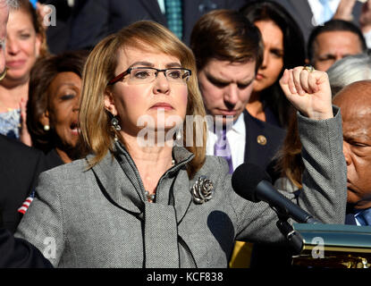 Washington, USA. Oktober 2017. Die ehemalige US-Repräsentantin Gabrielle Giffords (Demokrat von Arizona) hebt ihre Faust während ihrer Äußerungen, als die Demokraten des US-Repräsentantenhauses auf den Oststufen des US-Kapitols erscheinen, um eine Erklärung gegen die Waffengewalt nach dem Massaker in Las Vegas am Mittwoch, den 4. Oktober 2017, in Washington, DC abzugeben. Kredit: Ron Sachs/CNP - KEIN KABELSERVICE - Kredit: Ron Sachs/Consolidated/dpa/Alamy Live News Stockfoto