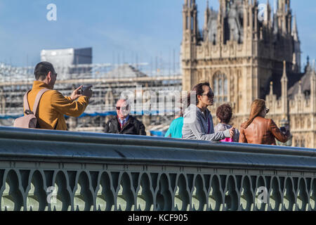 London, Großbritannien. 5. Okt, 2017. Menschen die morgen Herbst Sonnenschein auf die Westminster Bridge genießen zwar eine gelbe Wetter Warnung ausgegeben wurde als 60 mph Gale force Winde und Regen zu erwarten sind Teig vielen Teilen von England und Wales auf Donnerstag Nacht Kreditkarten: Amer ghazzal/alamy leben Nachrichten Stockfoto