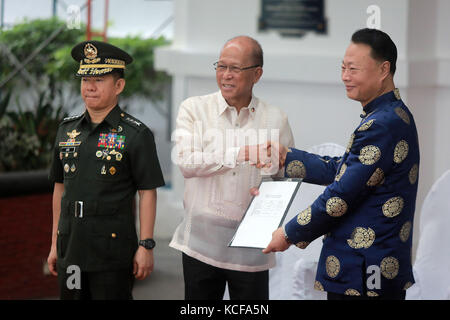 Manila, Philippinen. Oktober 2017. Der chinesische Botschafter auf den Philippinen Zhao Jianhua (R), der philippinische Verteidigungsminister Delfin Lorenzana (C) und General Eduardo Ano, der Stabschef der Streitkräfte der Philippinen, nehmen am 5. Oktober 2017 an einer Übergabe in Metro Manila auf den Philippinen Teil. Das philippinische Verteidigungsministerium erhielt am Donnerstag eine zweite Charge militärischer Ausrüstung, die China zur Unterstützung der Philippinen bei der Terrorismusbekämpfung spendete. Quelle: Rouelle Umali/Xinhua/Alamy Live News Stockfoto