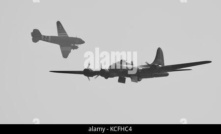 Boeing B-17 Flying Fortress Verbündeter b' mit einem Douglas C-47 Skytrain 'Drag-em-oot" im Hintergrund Stockfoto