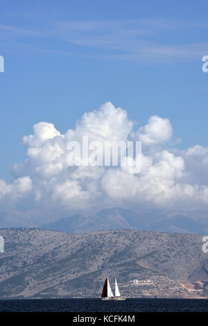 Zwei Yachten Segeln an der Küste von Korfu mit den albanischen Bergen im Hintergrund. Stockfoto