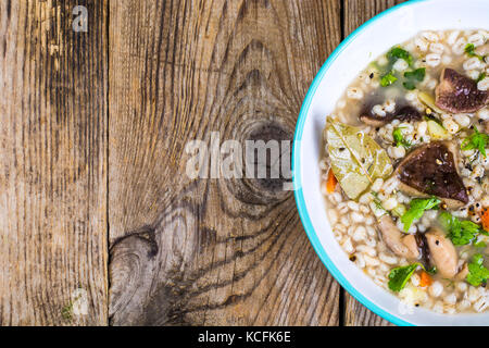 Vegetarische Suppe mit Pilzen und Graupen Mittagessen auf hölzernen Tisch Stockfoto