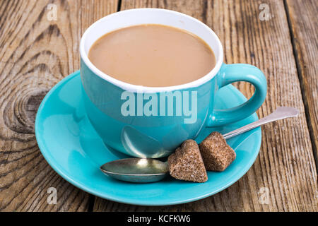 Kaffee mit Milch in blauer Schale, Stücke von Zucker Stockfoto