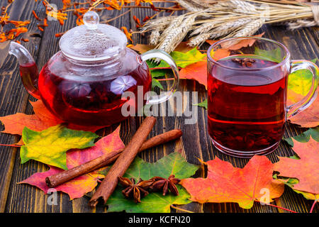 Roter Tee mit karkade, Herbst Blätter auf hölzernen Tisch Stockfoto