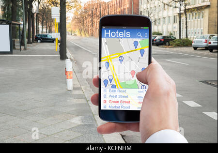 Nahaufnahme der Hand Person mittels GPS-Navigation im Handy Hotels zu finden Stockfoto