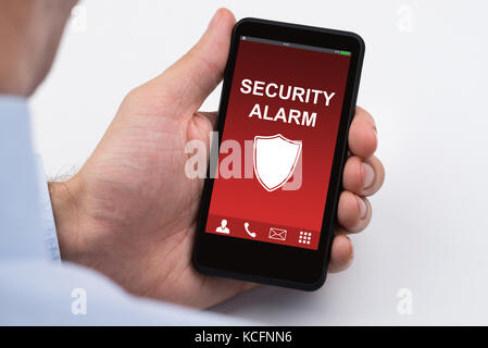 Nahaufnahme des Kaufmanns holding Handy Übersicht Sicherheit Alarm Stockfoto