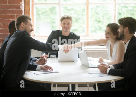 Corporate Kollegen treffen. Männliche executive Händeschütteln mit weiblichen Kollegen. Mitarbeiter Begrüßung und Einführung vor dem Briefing beginnt. Teammitglied Stockfoto