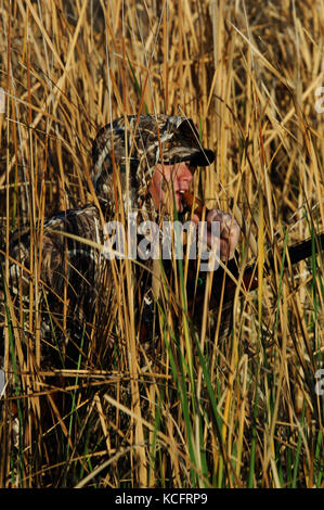 Eine Ente, Hunter in der Tarnung anrufe Enten aus einem Sumpf in South Texas Stockfoto