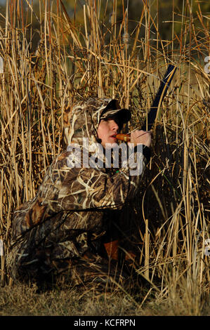 Eine Ente, Hunter in der Tarnung anrufe Enten aus einem Sumpf in South Texas Stockfoto