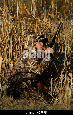 Eine Ente, Hunter in der Tarnung anrufe Enten aus einem Sumpf in South Texas Stockfoto