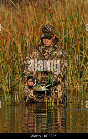 Eine Ente, Hunter in der Tarnung legt seine Jagd Lockvögel in einem South Texas Marsh Stockfoto