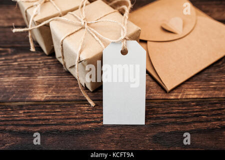 Mockup Kraftpapier Geschenkboxen mit Tag auf hölzernen Hintergrund Stockfoto