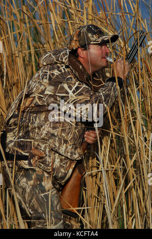 Eine Ente, Hunter in der Tarnung anrufe Enten aus einem Sumpf in South Texas Stockfoto